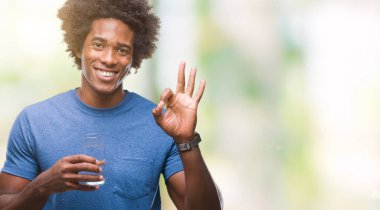 Afro Amerikalı adam parmak, mükemmel sembolü ile ok işareti yapıyor izole arka plan üzerinde bardak su içme