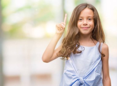 Gösterilen ve kendinden emin ve mutlu gülümseyen bir parmak ile işaret eden oktan yukarı esmer Latin kız.