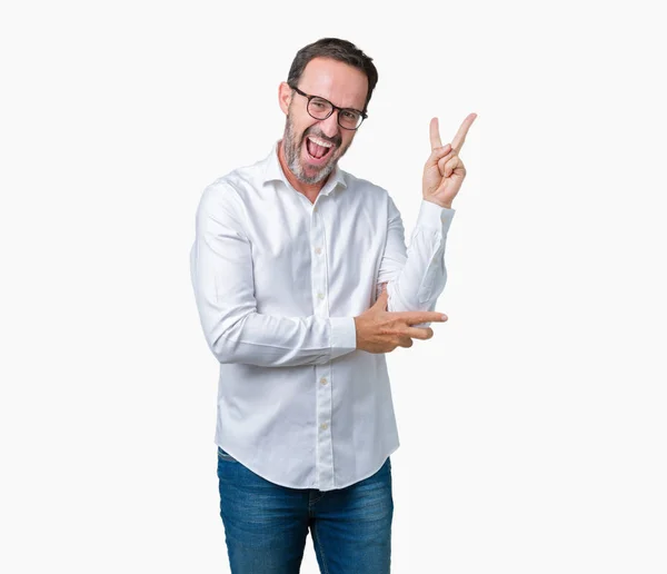 ハンサムな中年エレガントなシニア ビジネス男が眼鏡をかけて勝利のサインを行うカメラでウィンクしている幸せそうな顔を浮かべて隔離された背景の上 — ストック写真