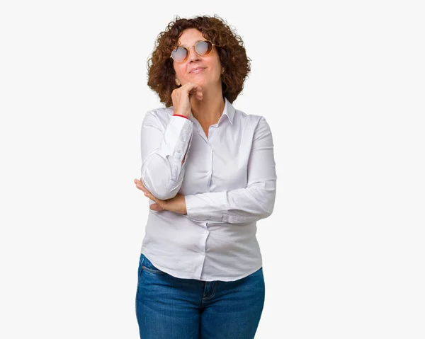 美しい中間エイガー シニア ビジネス女性のサングラスは あごを考えて質問 物思いにふける式に手でバック グラウンドを分離しました 思いやりのある顔をして笑っています 疑いのコンセプト — ストック写真
