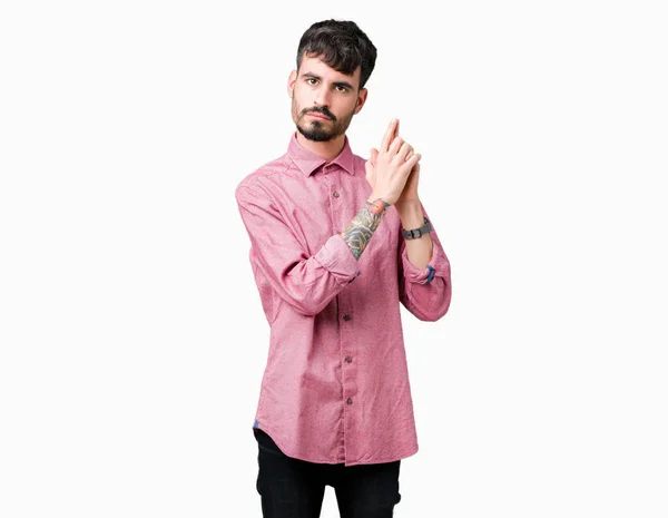 年轻英俊的男子穿着粉红色的衬衫在孤立的背景举行象征性的枪与手势 玩杀人射击武器 愤怒的脸 — 图库照片