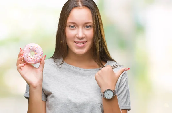 Mladá Kavkazský Žena Jíst Sladký Bonbónek Izolované Pozadí Ukazuje Ukazuje — Stock fotografie