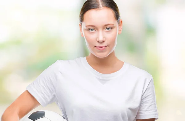 考えて深刻なスマートの顔に自信を持って式に分離された背景にサッカー サッカー ボールを保持している若い美しい白人女性 — ストック写真