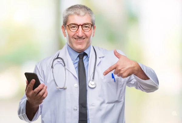 英俊的资深医生在孤立的背景下用智能手机发短信 惊讶的脸指着自己 — 图库照片