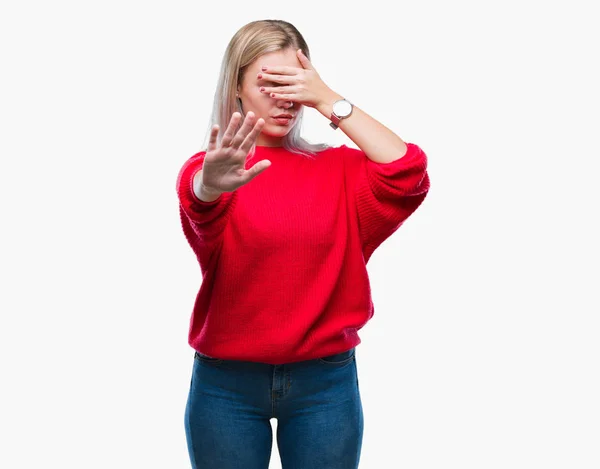 上冬セーター身に着けている若いブロンドの女性の手で目を覆っている背景を分離したと停止を行う悲しいとジェスチャーし恐怖表現 恥ずかしいと負の概念 — ストック写真