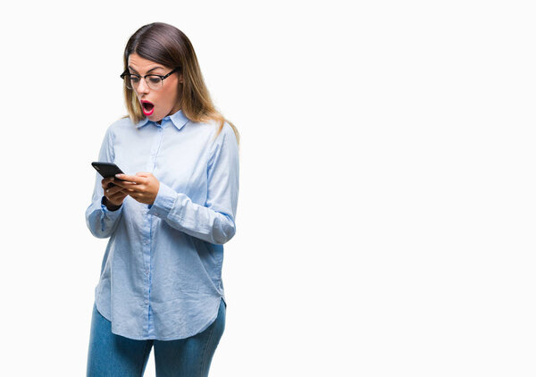 Young beautiful business woman texting message using smartphone over isolated background scared in shock with a surprise face, afraid and excited with fear expression