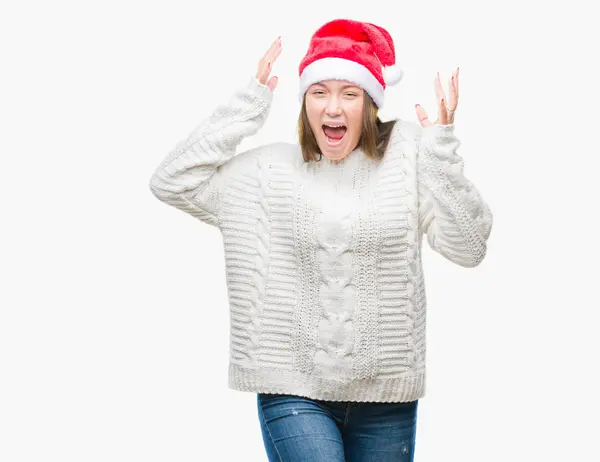 年轻美丽的白人妇女戴着圣诞节帽子在孤立的背景庆祝疯狂和惊讶的成功与双臂举起和睁开的眼睛尖叫兴奋 获奖者概念 — 图库照片