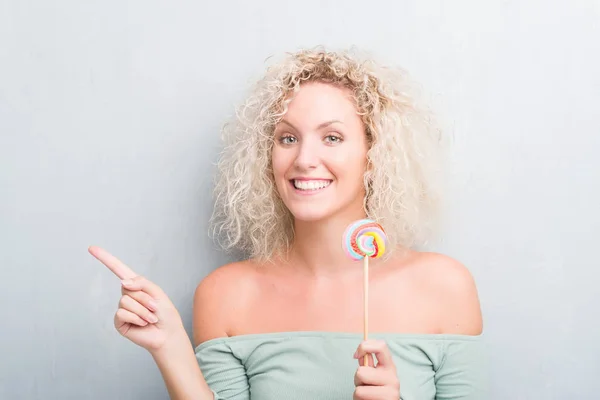 Sarışın Genç Kadın Candy Lolipop Parmak Ile Tarafına Işaret Çok — Stok fotoğraf