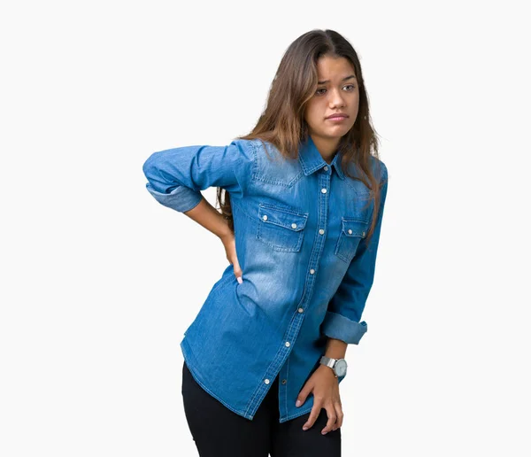 分離の上青いデニムのシャツを着て美しいブルネット女性背景苦しみ腰痛 筋肉痛 手に触れる — ストック写真