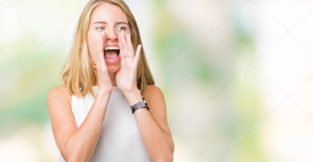 Beautiful young elegant woman over isolated background Shouting angry out loud with hands over mouth