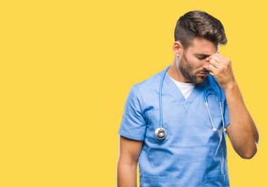 Genç yakışıklı izole arka plan üzerinde yorgun gözleri duygu yorgunluk ve baş ağrısı ve burun sürtme cerrah adam doktor. Stres ve hayal kırıklığı kavramı.