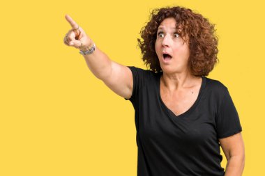 Güzel orta ager izole arka plan ile sürpriz devam et, parmakla üzerinde kadın kıdemli ağız açık ifade, önünde bir şey hayret