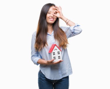 Genç Asyalı kadın gerçek durum Aracısı ile mutlu yüz el parmaklarının arasından seyir göz üzerinde ok işaretiyle yapıyor gülümseyen izole evin arka plan holding