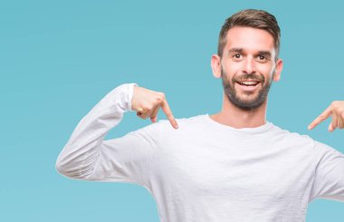 Yüzünde gülümseme ile kendinden emin görünüyorsun, kendini gururlu ve mutlu parmakları ile işaret izole arka plan üzerinde genç yakışıklı adam.