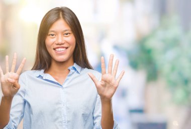 Genç Asyalı iş kadını gösterilen ve parmakları ile işaret izole arka plan üzerinde numara 9 kendinden emin ve mutlu gülümseyerek süre.