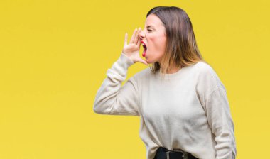 Genç güzel kadın rahat beyaz kazak bağırarak ve ağzı üzerinde el ile yan için çığlık izole arka plan üzerinde. İletişim kavramı.