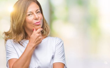 Orta yaş İspanyol kadın kıdemli emin çapraz kollar ve çeneme kaldırdı el ile gülümseme ile kameraya bakarak izole arka plan üzerinde. Pozitif düşünce.