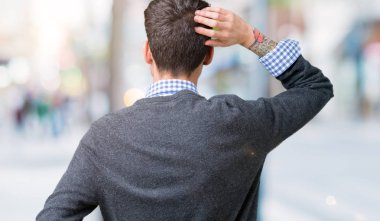 Genç yakışıklı izole arka plan geriye düşünme hakkında şüphe ile baş taraftan üzerinde gözlük takan adam akıllı