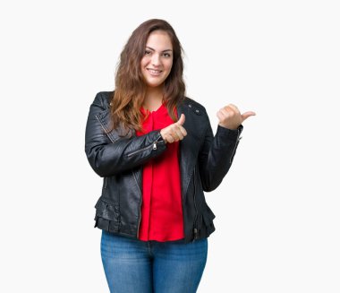 Artı boyutu genç kadın güzel üzerinde bir moda deri ceket giyiyor izole arka plan emin gülümseyen arkasından el ve kadar başparmak ile işaret