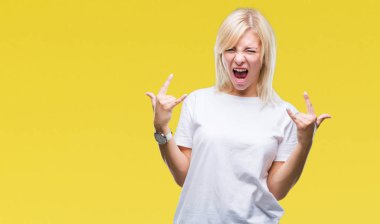 Deli ifade rock simge elle yapıyor ile bağırarak izole arka plan üzerinde beyaz t-shirt giyen genç güzel sarışın kadın. Müzik yıldızı. Ağır kavramı.