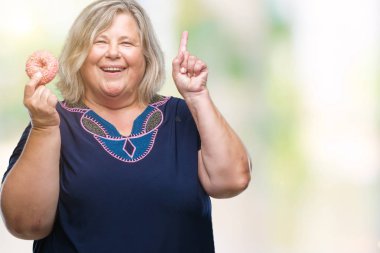 Kıdemli artı boyutu bir fikir veya gülen yüz, parmakla işaret eden soru ile kafkas kadın izole arka plan üzerinde şeker donut yemek şaşırttı bir numara