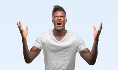 Genç Afro-Amerikan adam izole arka plan çılgın ve kızgın bağırarak ve agresif ifade ve silah kaldırdı bağırıyor. Hayal kırıklığı kavramı.