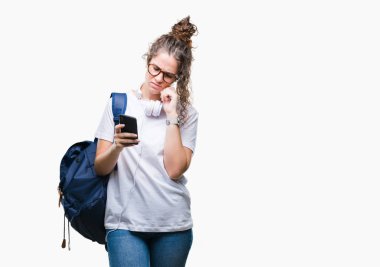 Sırt çantası, kulaklık ve smartphone izole arka plan ciddi bir yüz düşünme hakkında soru, çok karışık bir fikir üzerinde giyen genç esmer öğrenci kız