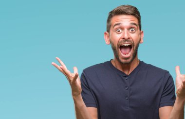 Yakışıklı delikanlı deli kutluyor ve silah ile başarı için heyecanlı çığlık kaldırdı ve açık gözleri hayret izole arka plan üzerinde. Kazanan kavramı