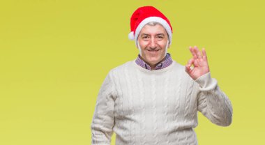 İzole arka plan el ve parmaklar ok işaretiyle yapıyor olumlu gülümseyen üzerinde Noel şapka yakışıklı komuta sizde. Başarılı ifade.