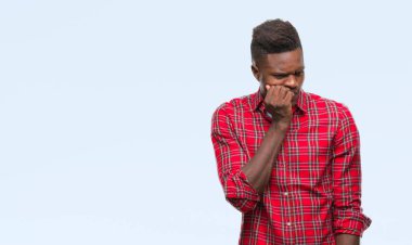 Genç Afro-Amerikan adam stresli ve gergin ile izole arka plan üzerinde tırnak ısırma dudaklarından eller. Anksiyete sorunu.