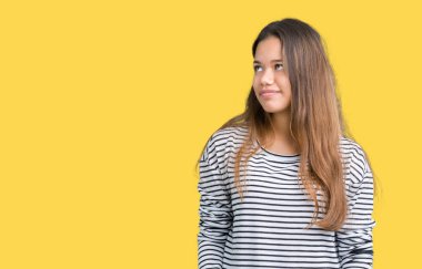 Giyen genç güzel esmer kadın kazak uzak tarafına yüzünde, doğal ifade gülümseme ile seyir izole arka plan üzerinde çizgili. Kendine güvenen gülüyor.