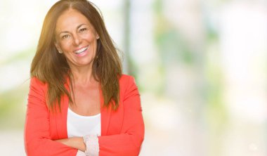 Güzel orta yaş iş yetişkin kadın izole arka plan mutlu yüz çapraz silah kameraya bakarak ile gülümseyen yüzünden. Olumlu bir kişi.