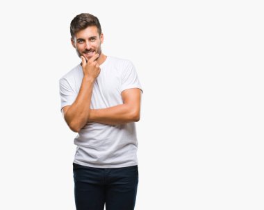 Yakışıklı delikanlı emin çapraz kollar ve çeneme kaldırdı el ile gülümseme ile kameraya bakarak izole arka plan üzerinde. Pozitif düşünce.