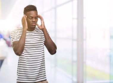 Gözlük ve lacivert t-shirt el ile baş ağrısı için kafasına çünkü giyen genç Afro-Amerikan adam stres. Migren muzdarip.