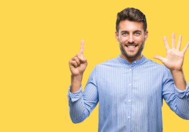 Yakışıklı delikanlı gösterilen ve parmakları ile işaret izole arka plan üzerinde kendinden emin ve mutlu gülümseyerek süre 6 numara.