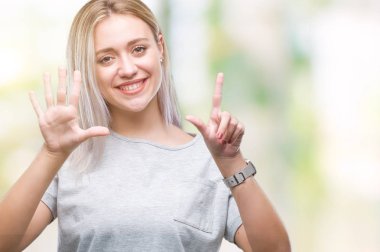 Genç Sarışın kadın gösterilen ve parmakları ile işaret izole arka plan yüzünden kendinden emin ve mutlu gülümseyerek süre yedi numara.