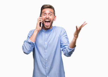 Kocaman bir gülümseme ile çığlık zaferini kutluyor ve ellerini kaldırdı izole arka plan çok mutlu ve heyecanlı, kazanan ifade üzerinde konuşan genç yakışıklı adam