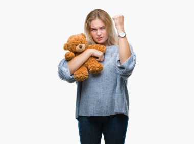 Sevimli Ayıcık izole tutan genç beyaz kadın arka plan ile öfke, çılgın ve yükseltilmiş eliyle diye bağıran rahatsız ve hayal kırıklığına uğramış öfke kavramı bağırarak