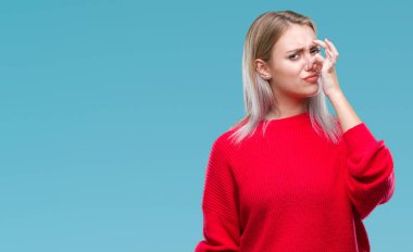 İzole arka plan kokulu üzerinde kış kazak pis ve iğrenç bir şey, dayanılmaz koku, holding nefes parmak ile burun üzerinde giyen genç sarışın kadın. Kötü kokuyor kavramı.