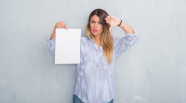 Gri grunge Genç Yetişkin kadın duvar kızgın yüzü, eksi işareti aşağı antipati başparmak ile gösterilen, ret kavramı ile boş kağıt levha holding