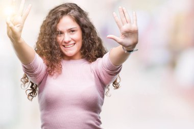 Gösterilen ve parmakları ile işaret izole arka plan üzerinde pembe kazak giyen güzel esmer kıvırcık saçlı Genç kız kendinden emin ve mutlu gülümseyerek süre sekiz numara.