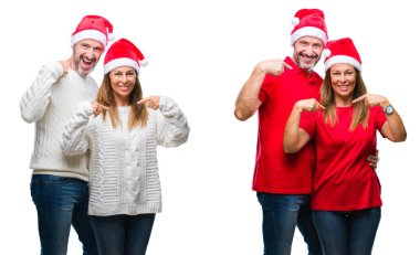 Orta yaş olgun güzel çift Noel şapka ile kendine güvenen seyir beyaz izole arka plan üzerinde kendini gururlu ve mutlu parmakları ile işaret yüzündeki gülümseme kolaj.
