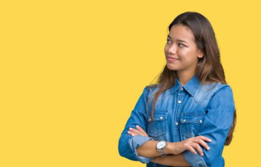 İkna ve kendine güvenen genç güzel esmer kadın tarafına silahlarla seyir gülümseyen izole arka plan üzerinde mavi kot gömlek giymiş geçti