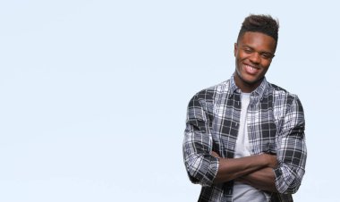 İzole arka plan mutlu yüz çapraz silah kameraya bakarak ile gülümseyen genç Afro-Amerikan adam. Olumlu bir kişi.