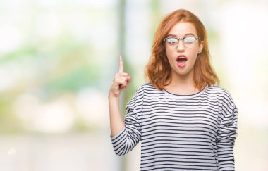 İzole arka plan başarılı fikirle parmağı yukarıyı gözlüklü genç güzel kadın. Çıktıktan ve mutlu. Bir numara.