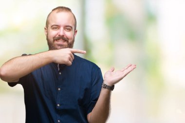 Genç beyaz hipster adam üzerinden hayran ve el ile sunulması ve parmak ile işaret ederken kameraya gülümseyen izole arka plan.