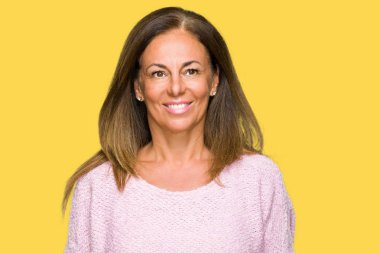 Yüzünde mutlu ve güzel bir gülümseme ile izole arka plan üzerinde kış kazak giyen güzel orta yaş yetişkin kadın. Şanslı kişi.