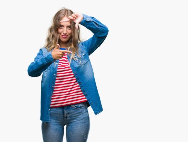 Güzel sarışın genç kadın elle yapma çerçeve ve parmakları ile mutlu yüz gülümseyen izole arka plan üzerinde. Yaratıcılık ve Fotoğrafçılık kavramı.