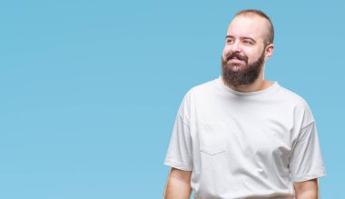 Üzerinde rahat t-shirt giyen genç beyaz hipster adam arka plan uzak tarafına gülümseme ile yüzünde, doğal ifade arıyorum izole. Kendine güvenen gülüyor.