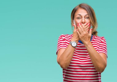 Orta yaş üst düzey İspanyol kadın izole arka plan ağız hata için elleriyle kapsayan şok yüzünden. Gizli kavramı.